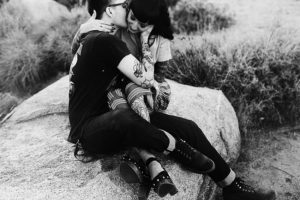 tattooed couple sitting on joshua tree rock