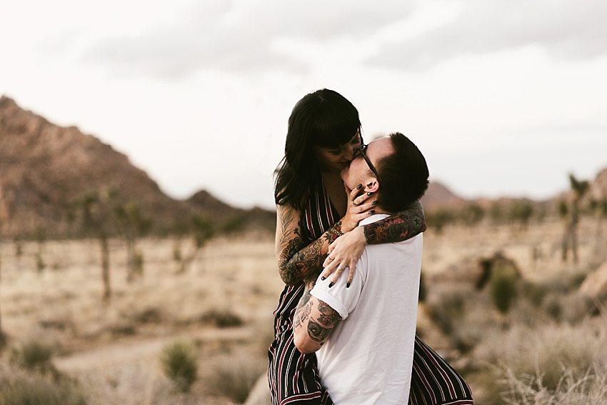 guy lifting girl and kissing in joshua tree national park