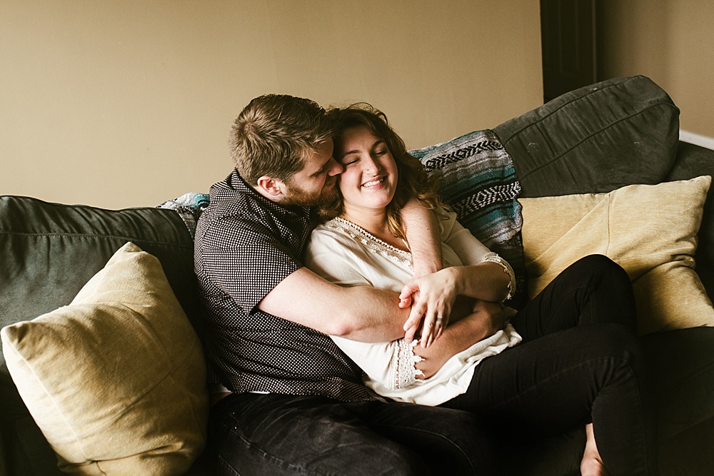 couple cuddling on couch in home family session