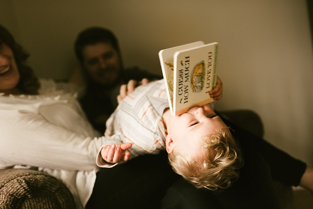 toddler being silly holding book in his mouth