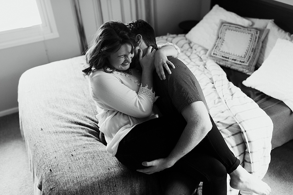 couple sitting on bed hugging