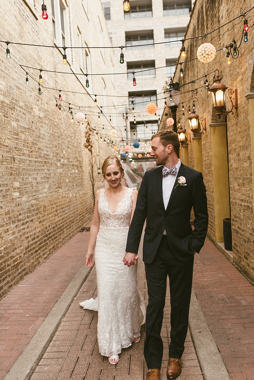 bride and groom walking in chicago alleyway