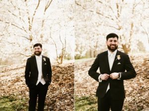 groom standing under white cherry blossoms at sweeney park