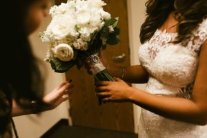 roses bouquets handing flowers to bride