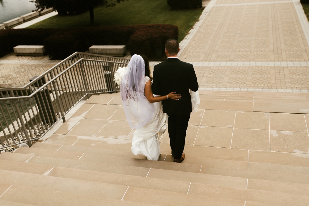 bride and groom walking downstairs at concordia lutheran seminary gardens