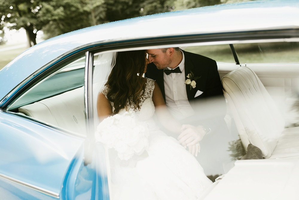 bride and groom in backseat of vintage impala