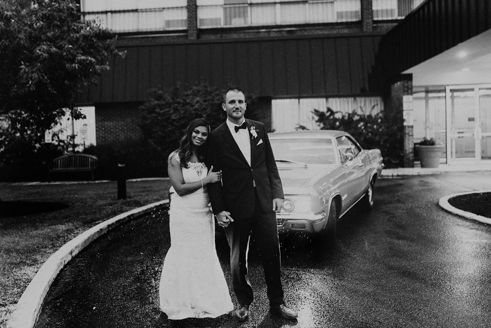 bride and groom smiling in front of vintage car