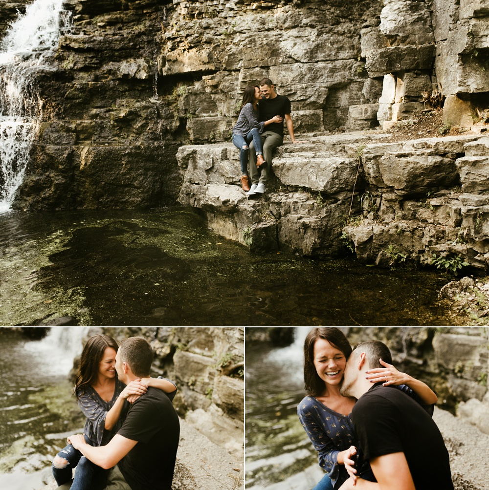 couple embracing next to waterfall during engagement session at france park