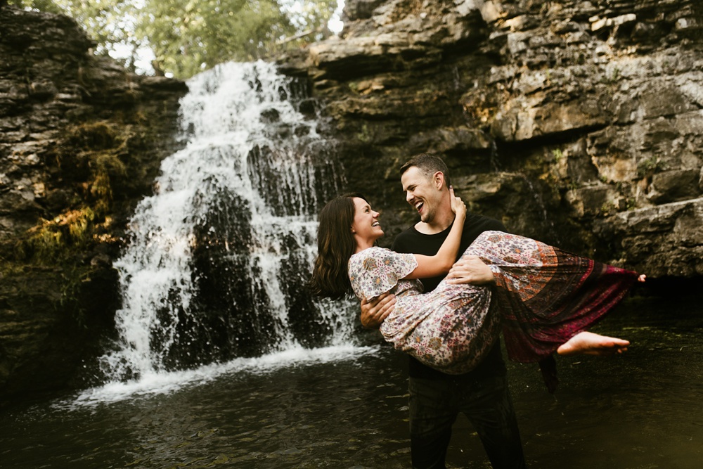 guy holding girl in front of france park waterfall engagement session