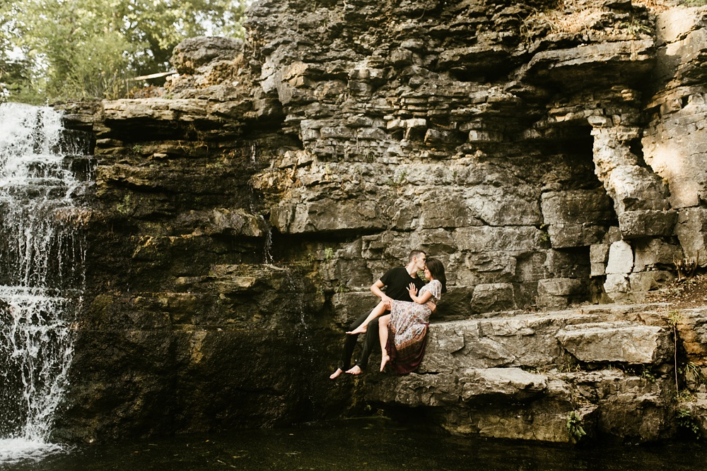 couple sitting on rock during engagement session at france park