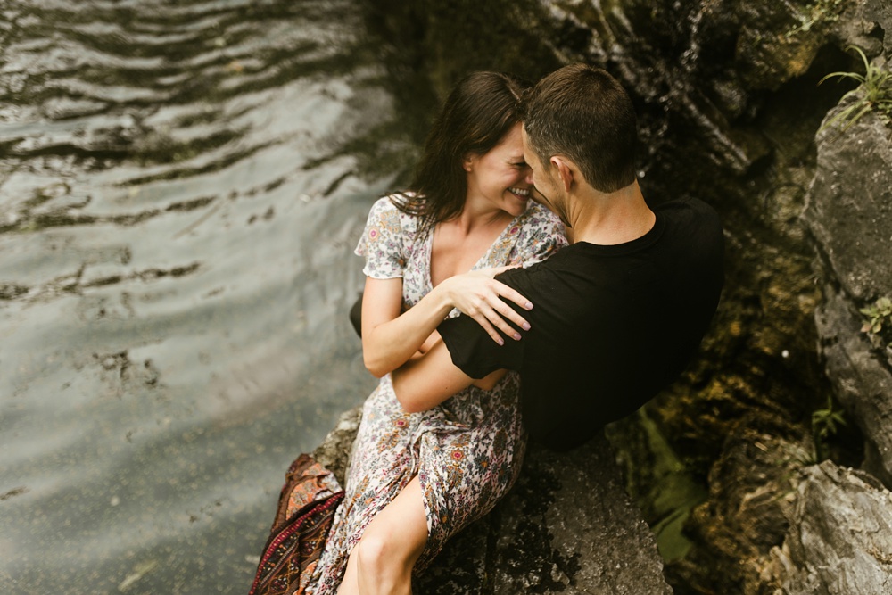 couple sitting next to waterfall during engagement session at france park