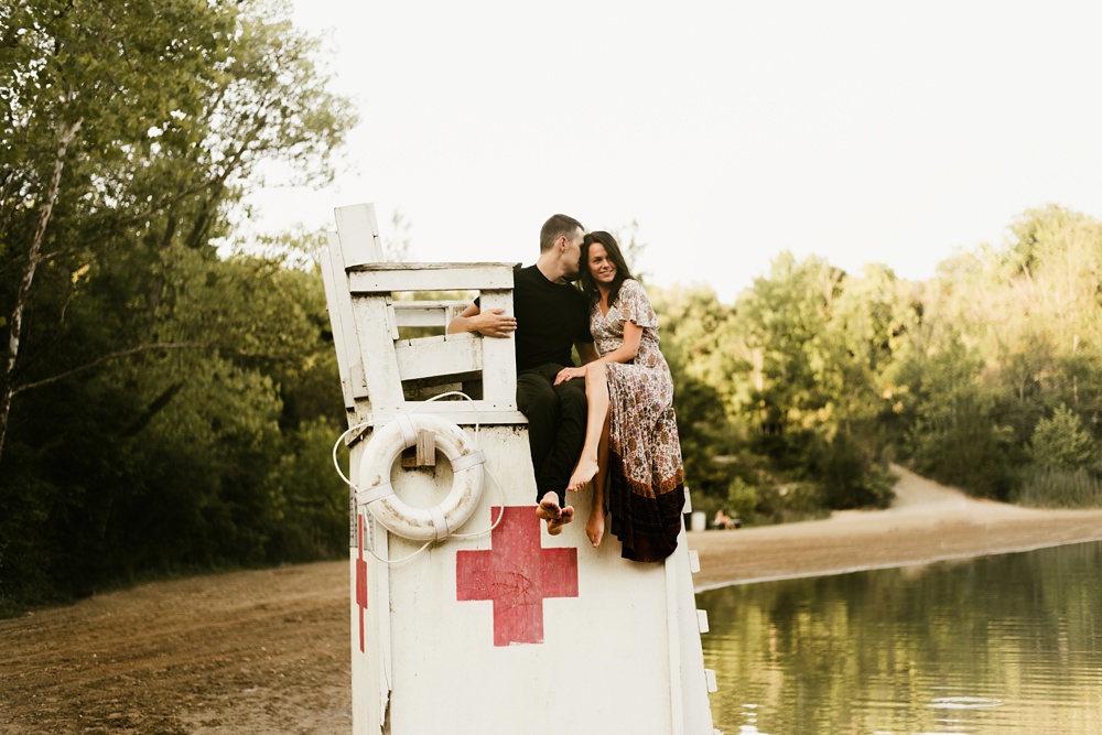 couple sitting on lifegaurd stand during engagement session at france park