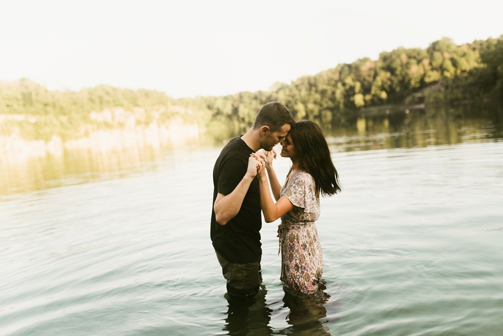 couple in quarry lake during engagement session at france park