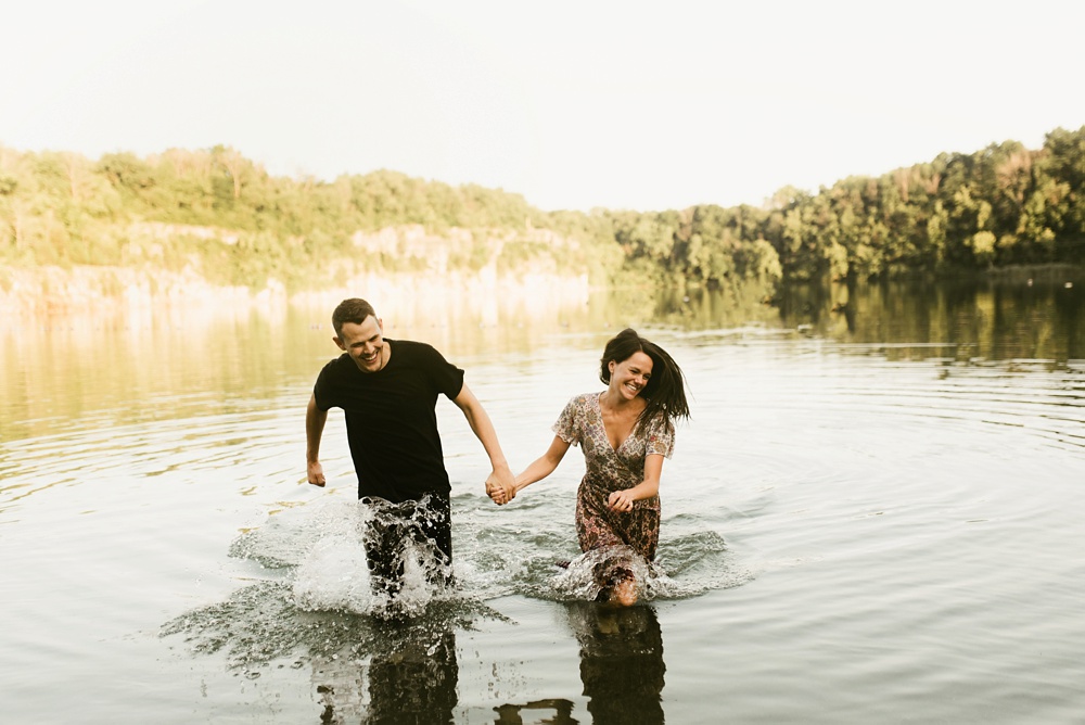 couple running through water during engagement session at france park