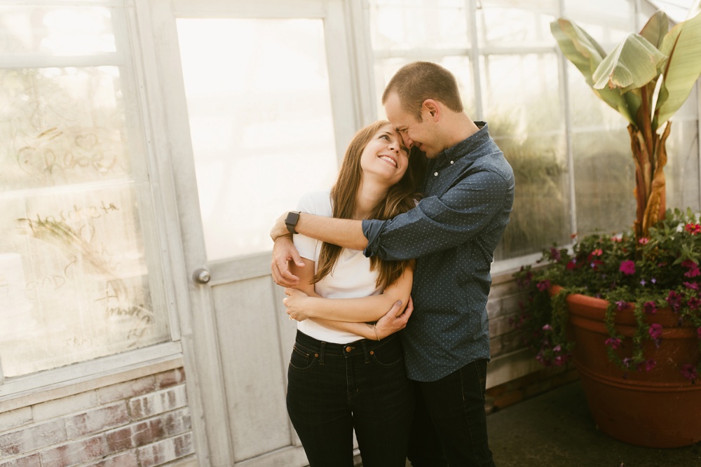 couple hugging in front of conservatory at belle isle detroit engagement session