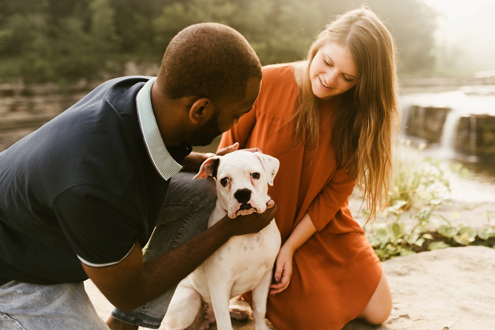 couple playing with dog during engagement session at cataract falls