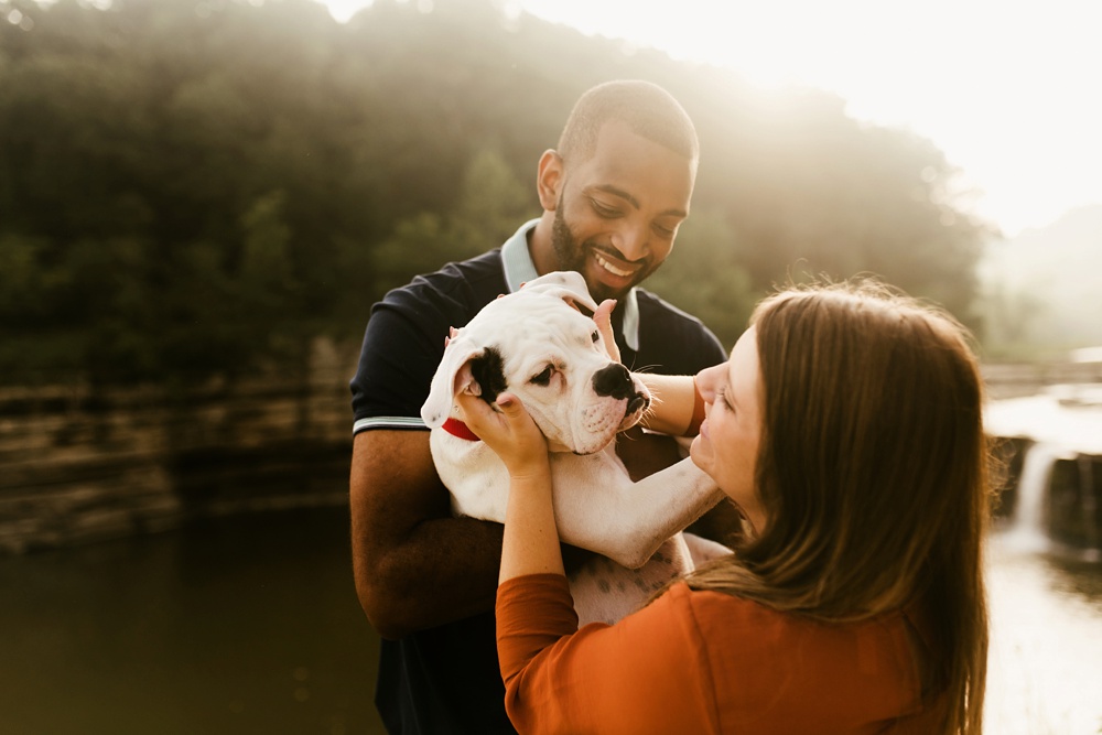 couple playing with dog during engagement session at cataract falls
