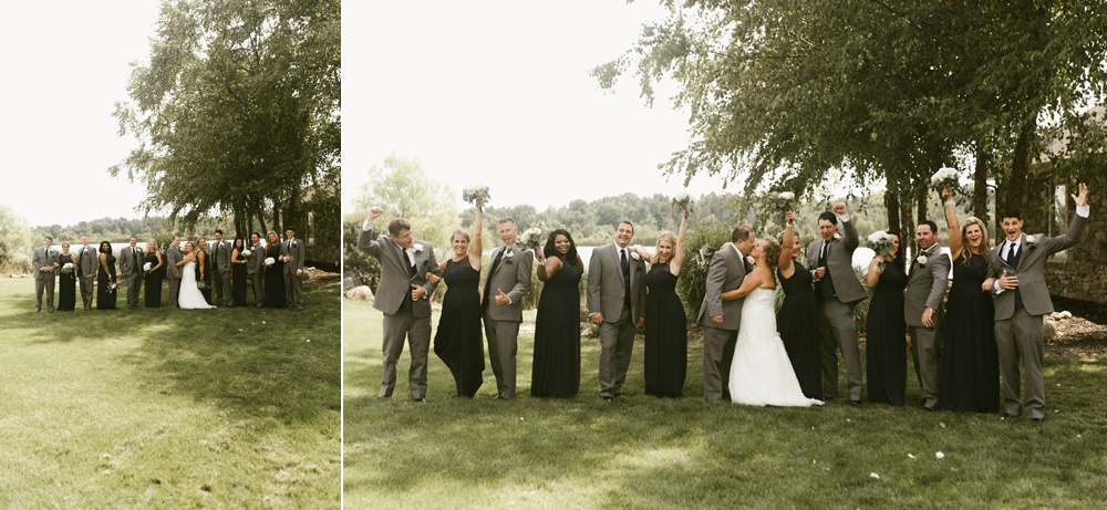 bridal party in gray tuxes and navy dresses cheering couple kissing at glendarin golf course