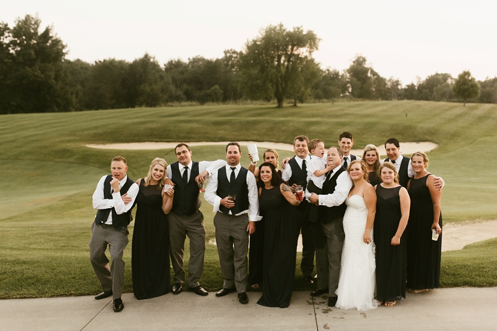 bridal party in navy dresses and gray tuxes with bride and groom at glendarin golf course sunset
