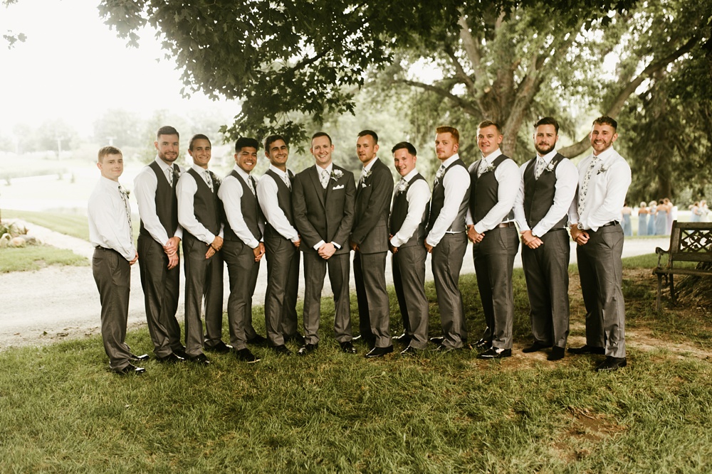 groomsmen and groom in dark gray tuxes at j weaver barn wedding