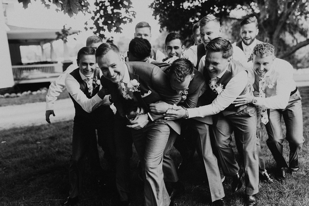 groomsmen wrestling groom at j weaver barn wedding