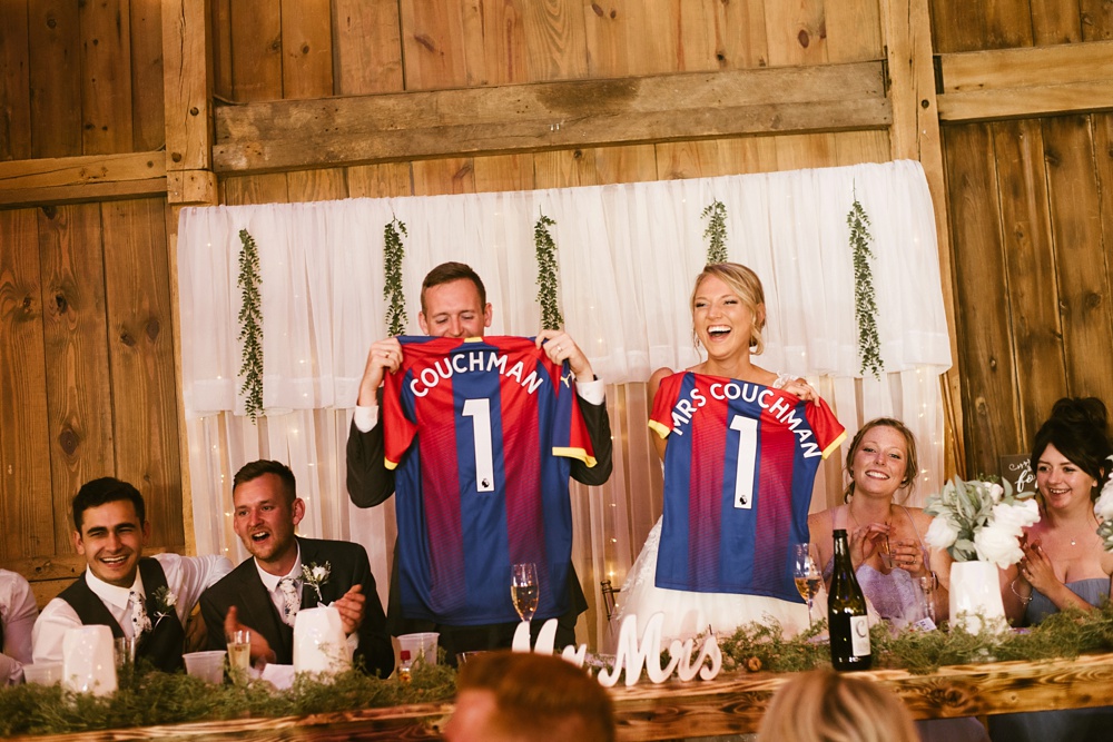 bride and groom with soccer jerseys at j weaver barn wedding