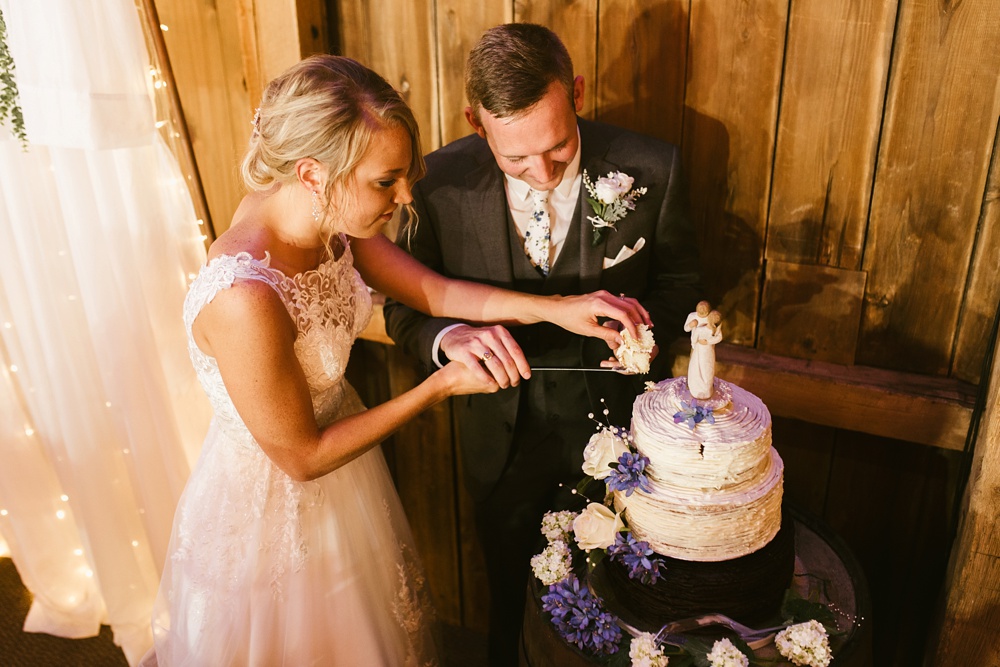bride and groom cutting cake at j weaver barn wedding