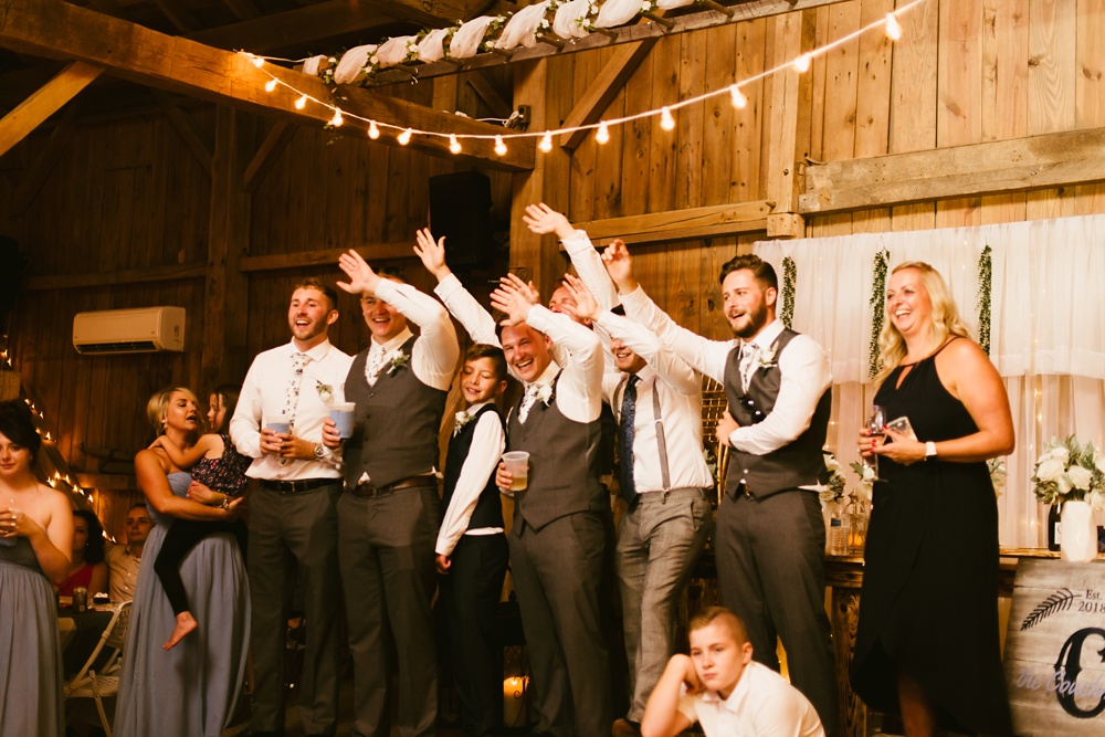 groomsmen waving at j weaver barn wedding