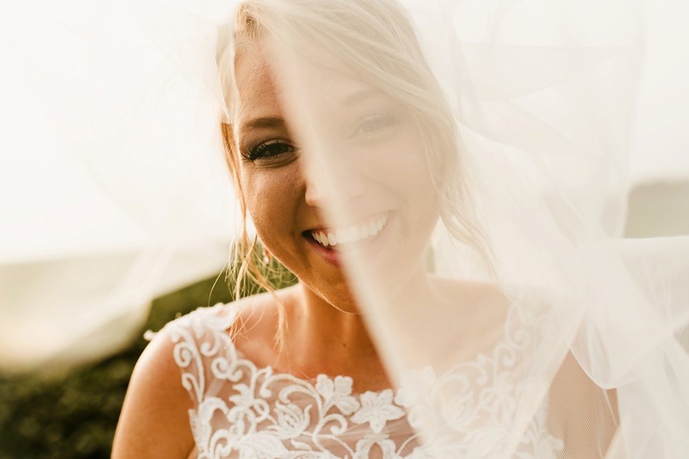 bride smiling through veil at j weaver barn wedding