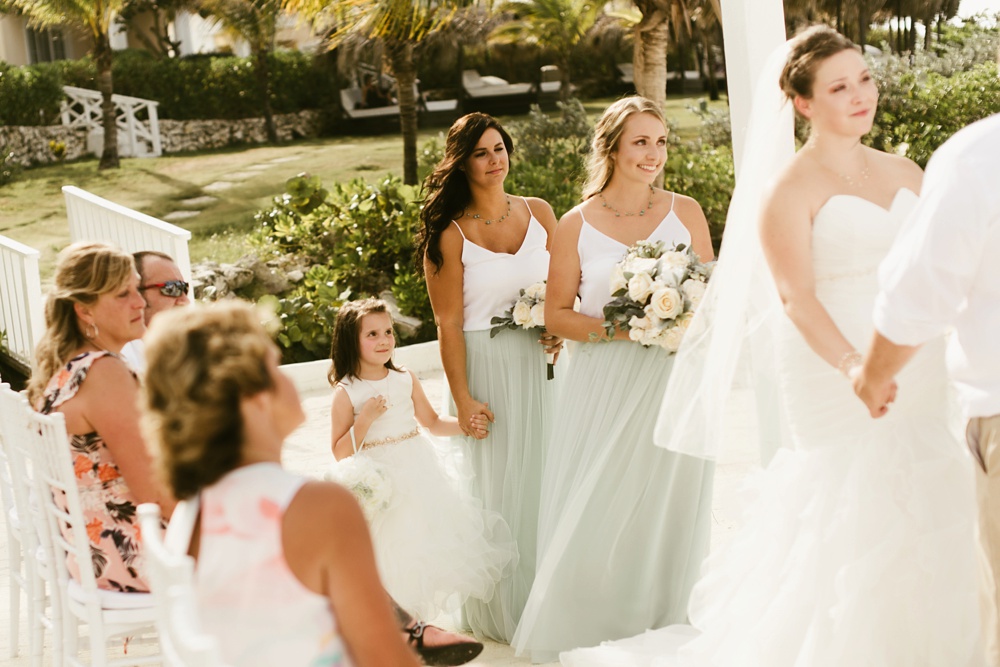 bridemaids in seafoam tulle skirts and white express tops with flower girl at ceremony at grand palladium jamaica wedding