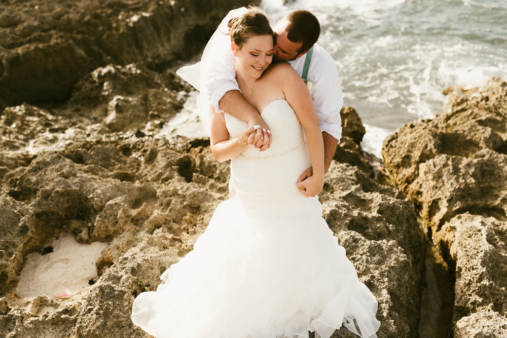 groom kissing bride oceanside at grand palladium jamaica wedding
