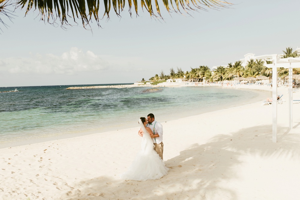 bride and groom kissing on beach at grand palladium jamaica wedding