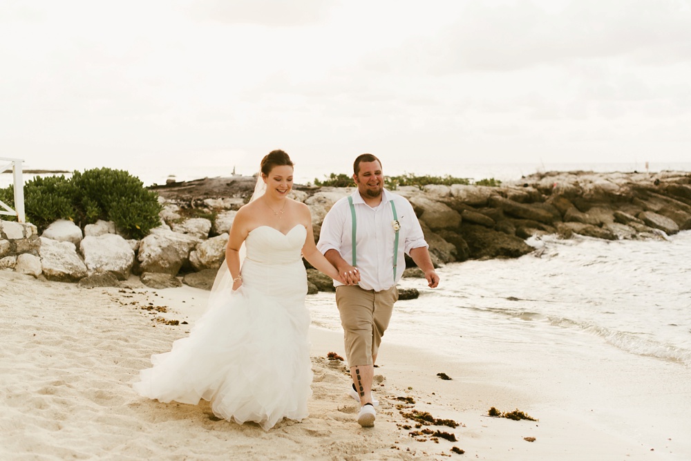 bride and groom walking down beach at grand palladium jamaica wedding