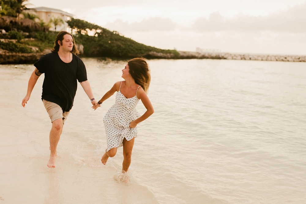 couple running holding hands on beach at grand palladium jamaica