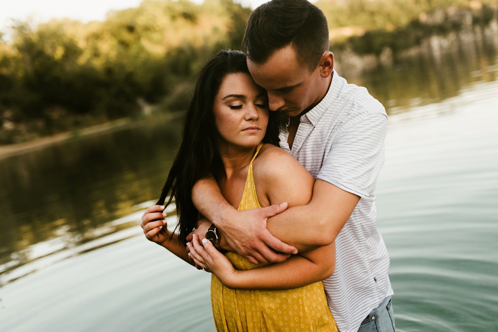 couple hugging and standing in water at indiana waterfall engagement photoshoot