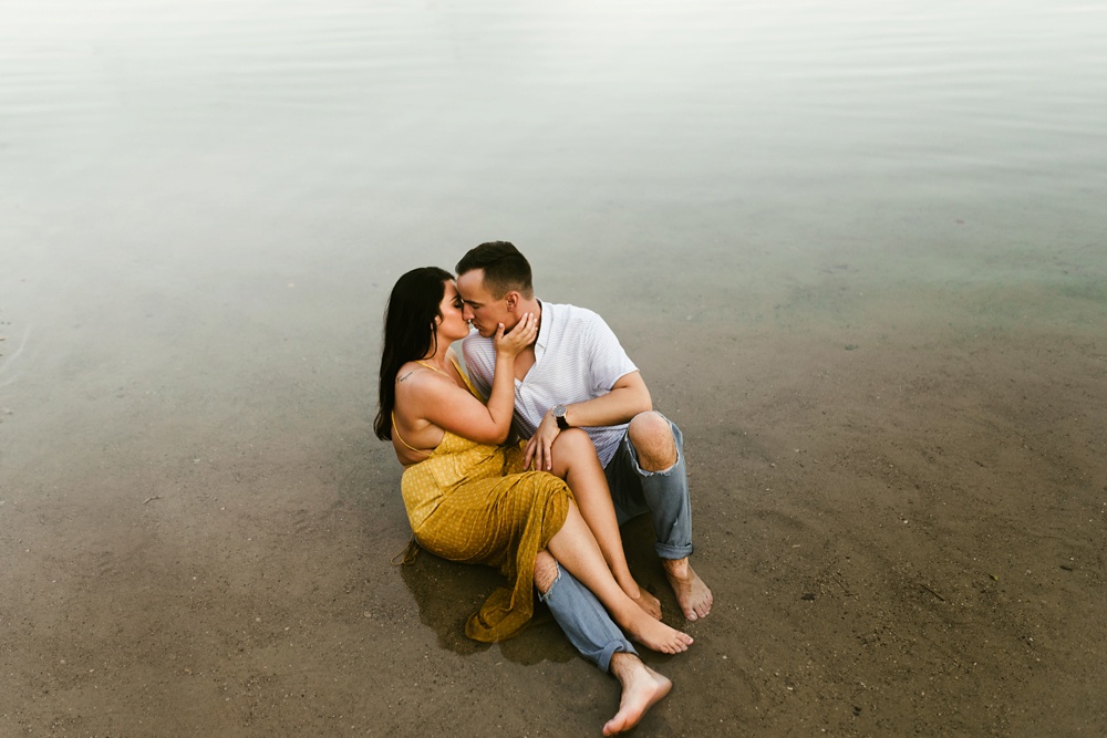 couple kissing on beach at indiana waterfall engagement photoshoot