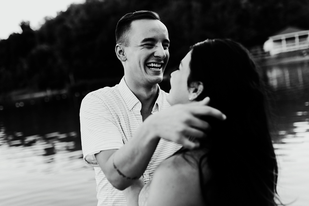 couple hugging and smiling in lake at indiana waterfall engagement photoshoot