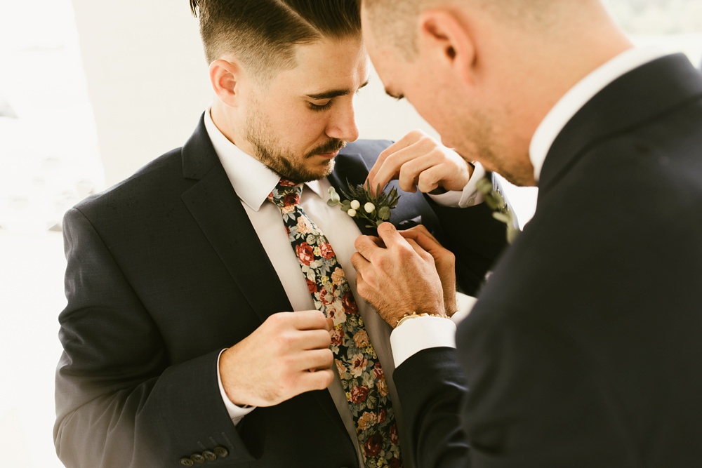 groom getting boutonniere put on before ceremony at pine valley country club wedding