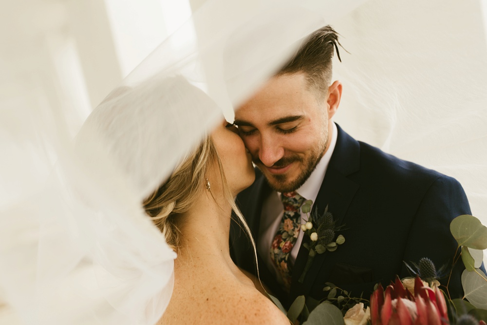 bride kissing groom at pine valley country club wedding