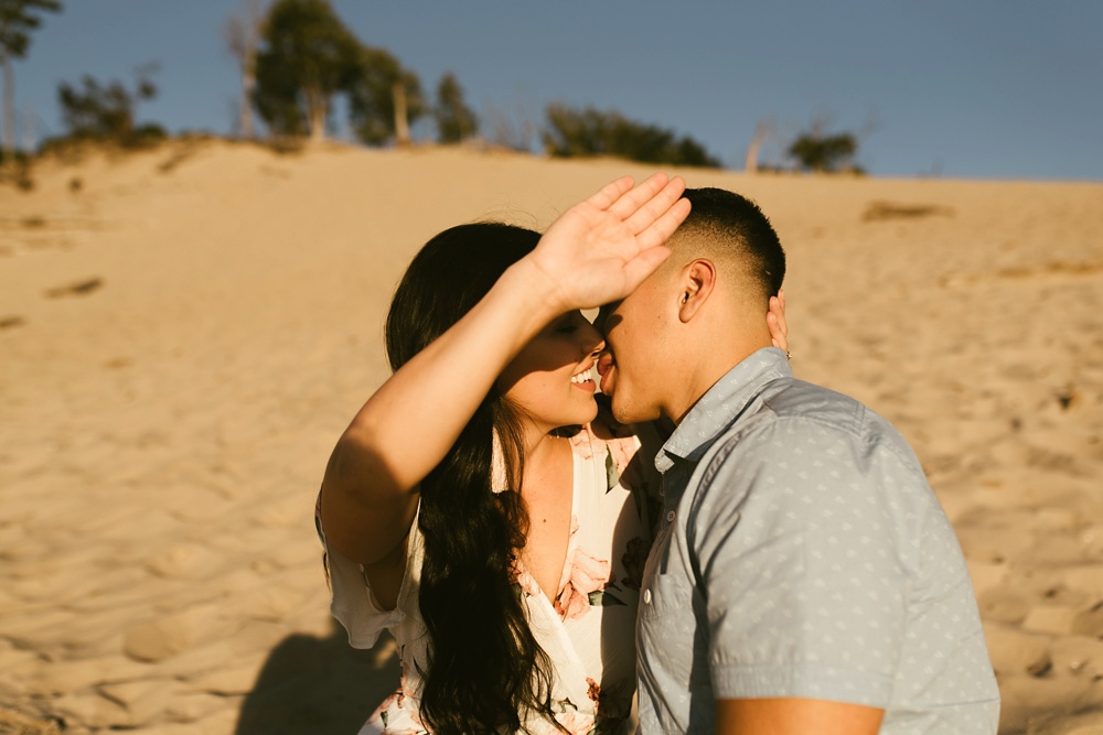 couple kissing at dune at warren dunes state park engagement session