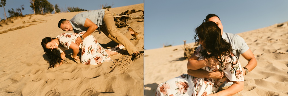 couple wresting at dune at warren dunes state park engagement session