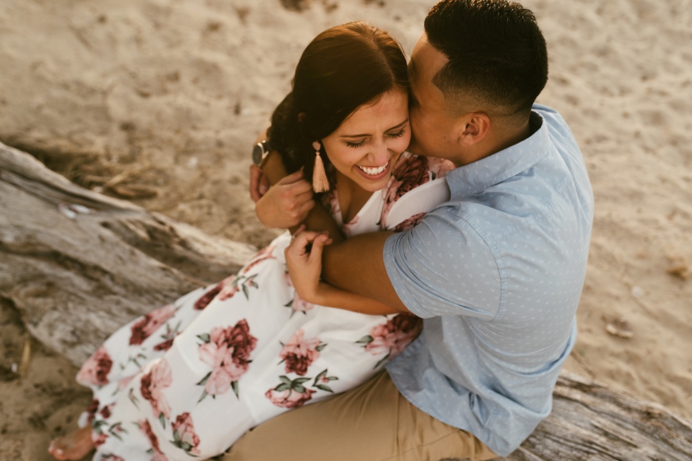 man kissing womans cheek at dune at warren dunes state park engagement session