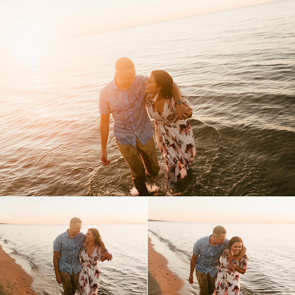 couple smiling walking along beach at dune at warren dunes state park engagement session