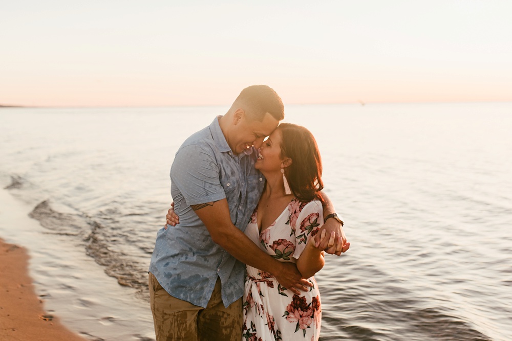 couple hugging lakeside at dune at warren dunes state park engagement session