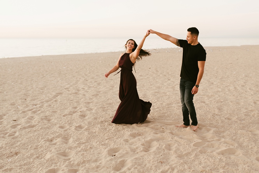 couple dancing on beach at dune at warren dunes state park engagement session