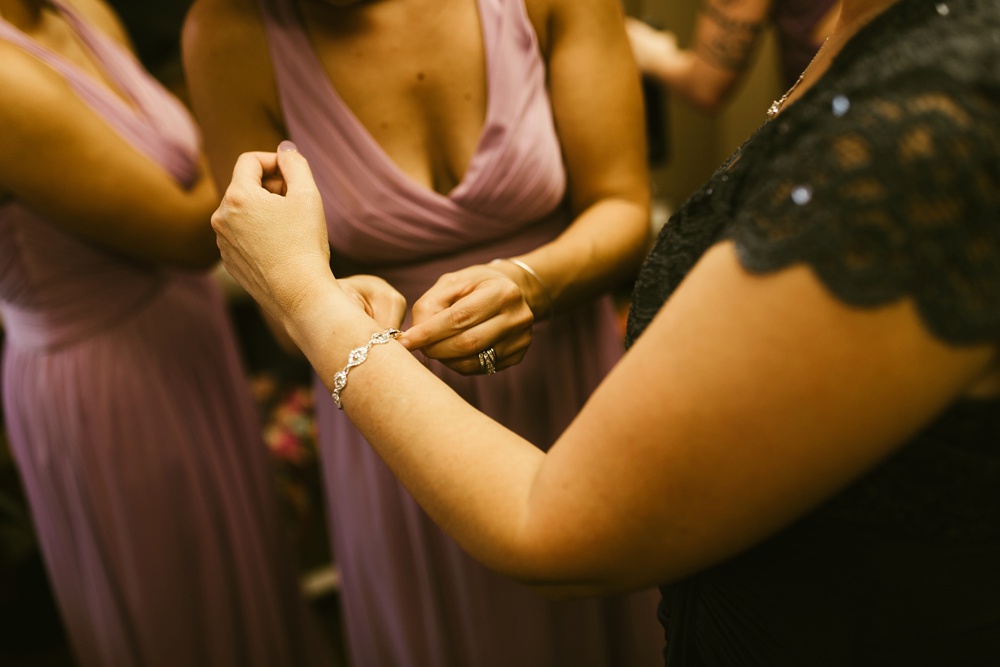 bridesmaids putting on brides bracelet at metea county park fall wedding