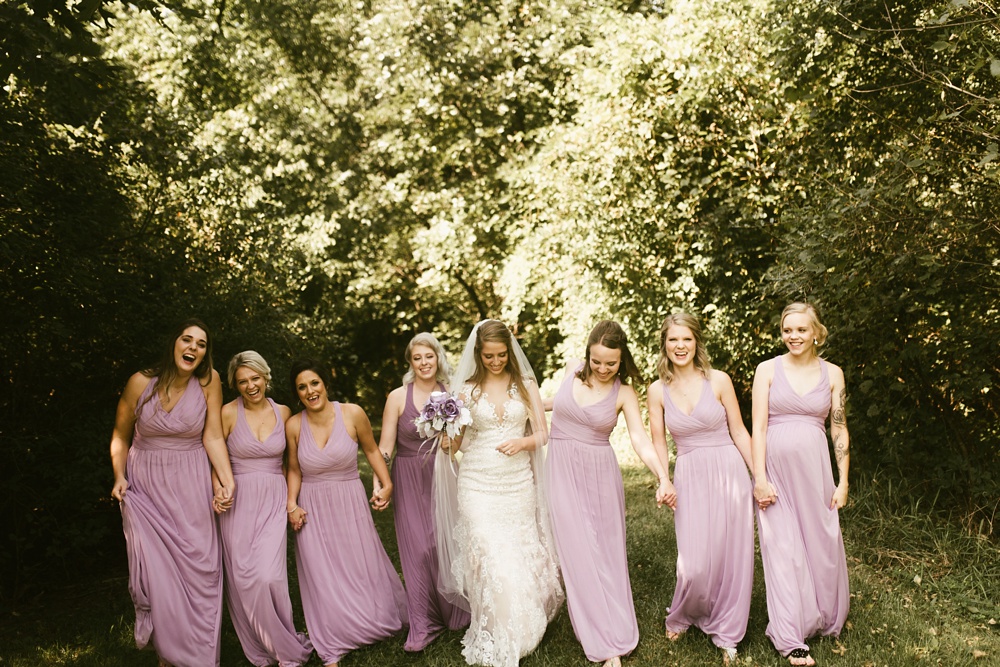 bride with bridesmaids in alvender dresses walking at metea county park fall wedding