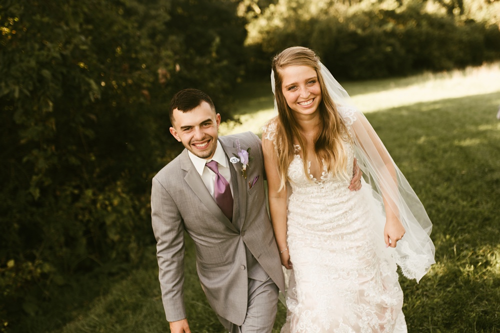 bride and groom smiling and holding hands at metea county park fall wedding