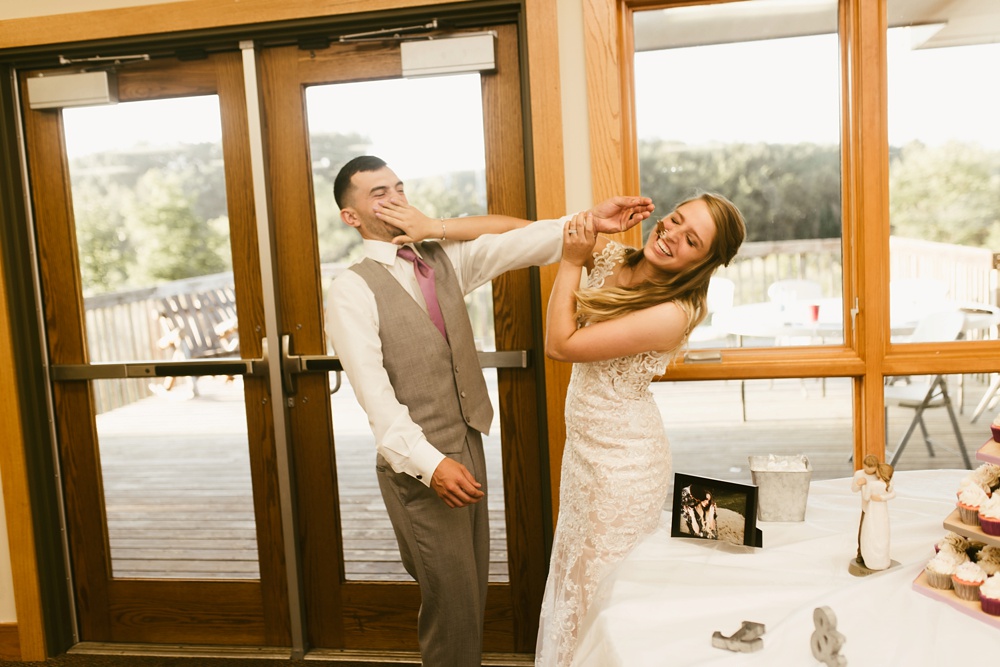 bride and groom fighting with cake at metea county park fall wedding