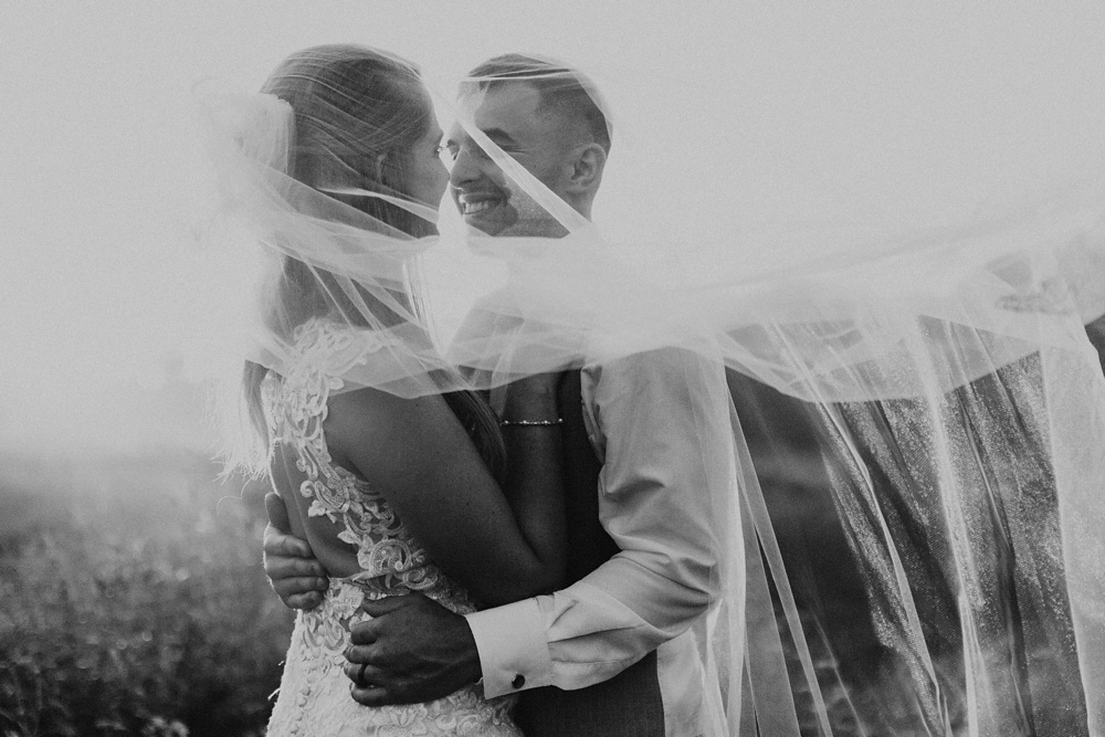 bride and groom hugging in veil at metea county park fall wedding